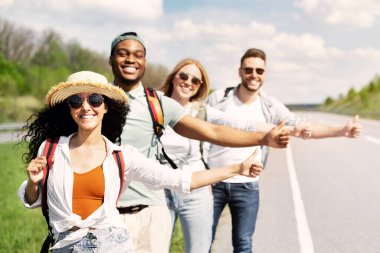 Otoyolda duran, otostop çeken, arabayı durduran, birlikte yolculuğa çıkan, kopyalayan çok ırklı genç arkadaşlar. Otomatik seyahat, yaz tatili, turizm ve arkadaşlık konsepti