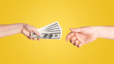 Close up of girl offering money to young guy against light background clipart