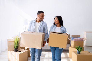 Yer ve daire kirası. Yeni eve karton kutular taşıyan, gülümseyen ve birbirlerine bakan Afro-Amerikan eşlerini sevmek. Gayrimenkul ve genç aile konutları