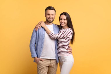 Bu neşeli çift birbirine yakın duruyor, canlı sarı bir arka planda sıcacık sarılıyorlar. Sevgiyi ve birlikteliği ifade ederler, mutlu ilişkilerini gösterirler..