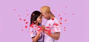 Sevgi dolu siyah bir çift yüzen kalplerle çevrili bir öpücükle bağlarını kutlar. Bu tatlı an, onların sevgisini neşe ve romantizm dolu özel bir anda yakalıyor..