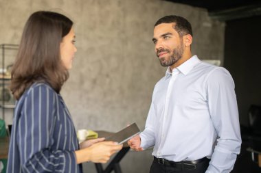 Modern bir ofiste iki profesyonel verimli bir tartışmaya giriştiler. İşbirlikçi bir atmosferde fikir ve materyal alışverişinde bulunarak, kariyerlerinde takım çalışması ve işbirliği örneği oluştururlar..