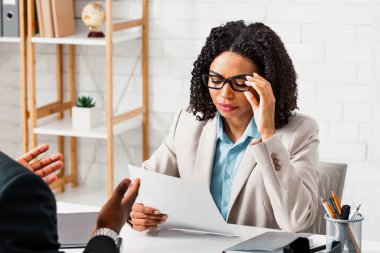Boş iş başvurularını okuyan kadın insan kaynakları yöneticisi iş görüşmesinde devam ediyor. Panorama