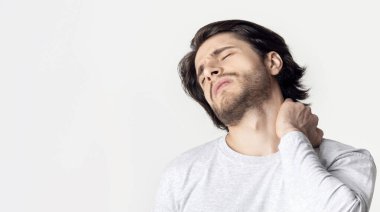 Boyun ağrısı. Adam elini acıyan yere bastırıyor, boş alana.