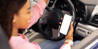 Beyaz ekranlı akıllı telefonu tutan mutlu siyah kadın sürücünün omuz manzarası üzerinde seyrüsefer için mobil uygulama kullanarak, maket yapın. Boş ekran ile cep telefonunu kapat, boşluk şablonunu kopyala