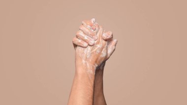 Virüse karşı hijyen. Mavi arka planda sabunla ellerini yıkayan adam, yakın plan görüntüsü. Kopyalama alanı olan Panorama