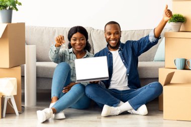 Mutlu Siyah Çift Ev Anahtarlarını Tutuyor ve Yeni Evlerine taşındıktan sonra Bilgisayarı Boş Ekranla Gösteriyor Neşeli Afro-Amerikan Eşleri Yeni Web Sitesi Tavsiye Ediyor, Model Resim