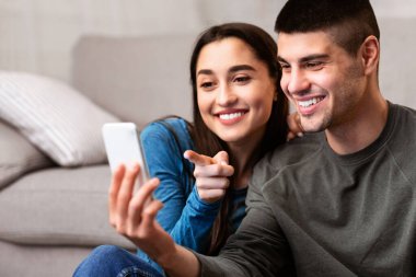 Medya İçeriği kavramının tadını çıkarıyorum. Güzel bir çift telefon kullanıyor, bir şey seçiyor, online sipariş veriyor, uzayı kopyalıyor.