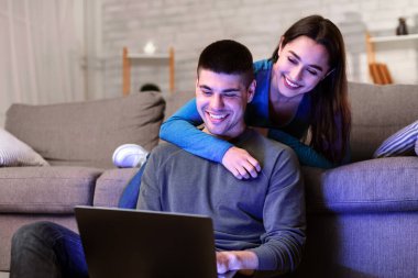 Ev Kavramında Rahatlamak. Tatlı çocuk ve kız bilgisayar kullanarak evlerinde vakit geçiriyorlar.