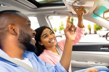 Araba basma düğmelerine basan Afrika kökenli Amerikalı bir çiftin arabanın güneşli çatısını açması ya da galeride otomobil denemesi yapan araçları incelemesi. Otomobil, test sürüşü satın alınıyor. Seçici Odaklanma