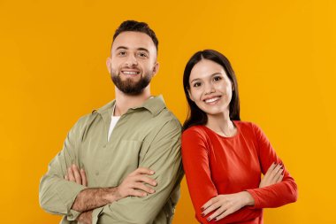 Genç bir çift kollarını kavuşturup yan yana durur, takım elbise giyerler. Parlak bir şekilde gülümserler, bu neşeli anda sevgilerini ve bağlantılarını gösterirler..