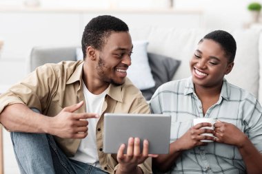 Siyah Turistler Dijital Tablet Rezervasyon Biletleri ve Otelin Çevrimiçi Planlama Tatil ve Evde Paketleme Bavulu Kullanıyorlar. Seyahat sitesi ya da Uygulama Reklamı. Seçici Odaklanma