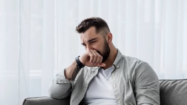 Üzgün, üzgün, çekici bir adam evdeki kanepede ağlıyor. Yalnız, yorgun ve endişeli. Psikolojik sağlık ve izolasyon yüzünden depresyonda. Psikoloji, yalnızlık ve zihinsel orta yaş krizi
