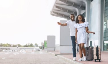 Havaalanından transfer. Otopark Terminali yakınlarında taksiye binen genç Afrikalı çift, anlaşıldı.