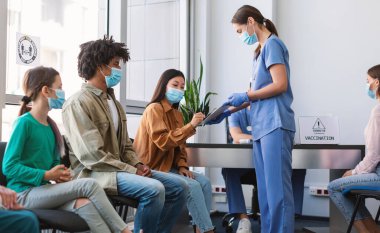 Coronavirus Tedavisi ve Aşı. Hastane bekleme odasında, Maskeli Asyalı Kadın, Doktor ile İmza Belgeleri. Corona Virüs Bağışçılarından Plazma Bağışları, Covid-19 Pandemik Tıbbi Kampanya Konsepti