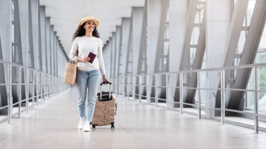 Tatil gezisi. Havalimanında Hasır Şapka Giyen Gülümseyen Kadın, Pasaportlu Mutlu Milenyum Kadını ve Ayrılık Kapısı 'na Giden Biletler, Seyahate Hazır, Kopya Boşluğu