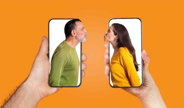 Bir çift ellerinde yüzlerini gösteren akıllı telefonlar tutuyor, sevgilerini vurguluyorlar. Parlak arkaplan, metin ve mesajlaşma yoluyla bağlantılarının sıcaklığını artırır.