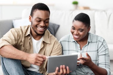 Mutlu Siyah Gezginler, Dijital Tablet ile Seyahat Varış Yeri Çevrimiçi Evdeki Bavulun Yakınındaki Katta Oturuyor. İnternet gezen turistler. Seçici Odaklanma