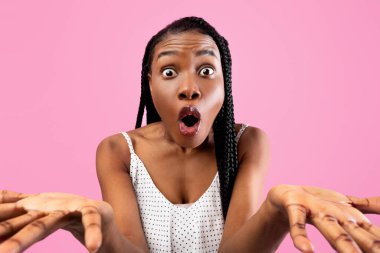 Arican Amerikalı kadının kameraya bakıp pembe stüdyo arka planında el kol hareketi yapmasına şaşırdım. Genç siyahi kadın şaşkınlıkla ağzını açıyor. İnsanlar, insan duyguları konsepti