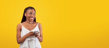 Akıllı telefon kullanan neşeli genç siyahi kadın, internette sohbet eden, video izleyen, pembe arka plandaki boş alana bakan, afiş tasarımı yapan. Afrikalı Amerikalı kadın sörf ağı, sosyal medyada paylaşım