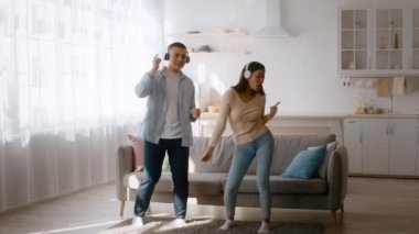 Genç bir çift sıcak oturma odalarında neşeyle dans ediyor. Kulaklık takıp birbirlerine gülümserken müzik dinliyorlar. Güneş ışığı pencerelerden geçer, boşluğu aydınlatır..