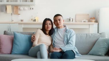 Genç bir çift şık bir oturma odasında rahat bir kanepede oturuyor. Sevgi dolu bir anı paylaşıyorlar, el ele tutuşup kameraya bakıyorlar. Dekor yumuşak renklere sahiptir.