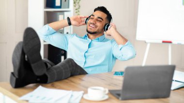 İşe ara verdim. Gülümseyen Arap adam kulaklıkla müzik dinliyor, iş yerinde dinleniyor. Mutlu milenyum çocuğu dizüstü bilgisayarla masada oturuyor ve en sevdiği şarkının tadını çıkarıyor.