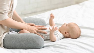 Bebek bakımı. Kolikleri, ekinleri önleyen oğlunun karnına masaj yapıyor