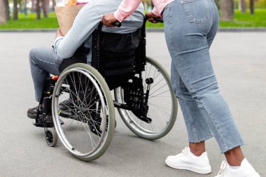 Tekerlekli sandalyedeki engelli genç adam elinde yiyecek dolu kağıt torbayla karısına kavuştuğu sırada eve dönüyor. Güz parkında birlikte yürüyen maskeli fakir bir çift.