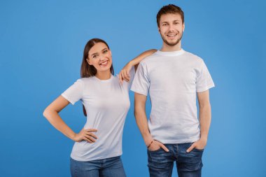 Kameraya poz veren neşeli partnerlerin stüdyo görüntüleri, mor duvarda izole edilmiş erkek arkadaşının elini tutan kadın.