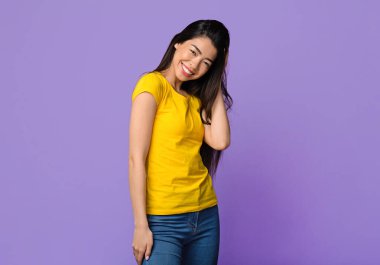 Neşeli Asyalı kadının, güzel saçlarına ve geçmişine dokunup poz verdiği, gençliğin tadını çıkardığı, iyi bir ruh halinde olduğu, kameraya bakıp gülümseyen Koreli kadının stüdyo portresi.