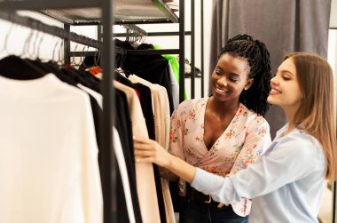 Kişisel Alışverişçi. Moda stilisti, müşterisinin moda mağazasından kıyafet almasına yardım ediyor. Boşluğu Kopyala