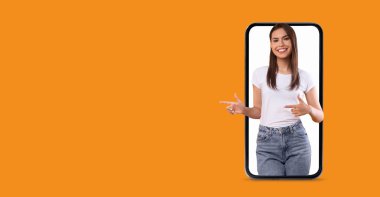 Dost canlısı bir yüz ifadesi olan bir insan büyük bir akıllı telefon ekranı ile etkileşime girer. Bunlar, canlı bir arkaplan üzerine kurulmuş iletişim ve teknolojiyle ilgili özellikleri vurguluyorlar..