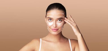 Bir kadın cilt bakımı rutinine başlar, ürünlerini yüzüne nazikçe uygular. İzole, sakin bir ortamda, rahatlamak ve güzelleşmek için mükemmel bir şekilde kendine bakmanın tadını çıkarıyor..