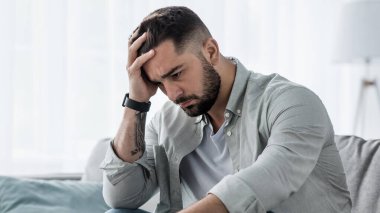 Çekici adam umutsuzca, üzgün, endişeli, düşünceli ve yalnız görünüyor. Evdeki koltukta depresyona giriyor. Orta yaş krizinde, zihinsel sağlık sorunları ve yaşam tarzı sorunları yaşıyor.