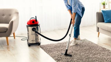 Ev ve Temizlik Konsepti. Halı halısında elektrikli süpürge kullanan, müzik dinleyen, kablosuz kulaklık takan, bedava fotokopi çeken sıradan bir kadın. Milenyum kadını günlük hayatın tadını çıkarıyor.
