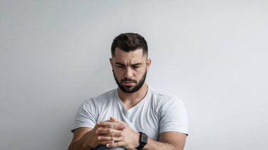 Negatif insani duygular, derin depresyon, yalnızlık, üzüntü, stres ve psikolojik sorunlar. Ciddi yakışıklı, kaslı, sakallı adam kaygılı, gri duvarlı arka planda, kopyalama alanı