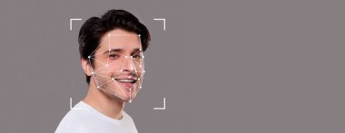 Genç bir adam gülümsüyor, yüzü yüz tanıma noktalarıyla ön plana çıkıyor. Bu teknoloji, kişisel güvenlikteki modern gelişmeleri vurgulayarak, çeşitli uygulamalarda kimlik tespitini artırır..