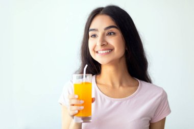 Neşeli Hintli kadın elinde bir bardak taze meyve suyu tutuyor, fotokopi odası. Neşeli Hindu bayan lezzetli içkisinin tadını çıkarıyor. Yaz detoksu, sağlık, diyet konsepti.