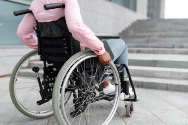 Tekerlekli sandalyedeki tanınmayan siyahi, belden aşağısı felçli kadın merdivenleri rampasız çıkamaz. Sınırlı ve mutsuz hisseder. Uzayı kopyala Engellilik, çevre, hareketlilik ve sosyal katılım