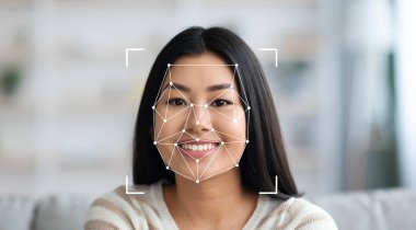 Yüz tanıma teknolojisi özelliklerini incelerken uzun saçlı bir kadın kameraya gülümsüyor. Arka planda konfor ve sıcaklığı vurgulayan samimi bir iç mekan var..