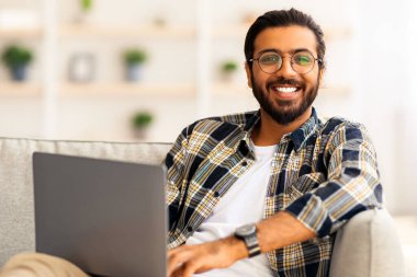 Pozitif Hintli adam dizüstü bilgisayarla kanepede yatar, film izler ya da flört sitesinde bayanlarla sohbet eder hafta sonları dinlenirken, evden çalışan orta doğulu serbest yazar, boşluğu taklit eder.