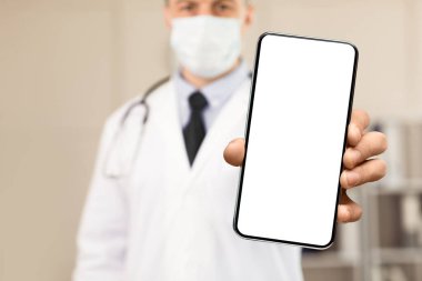 Dikkatli ol Kavram. Erkek doktor ya da bilim adamının koruyucu yüz maskesi takıp kameraya göstermesi.