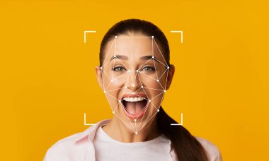 Yüz tanıma teknolojisi özelliklerini tanımlarken, bir kadın mutluluğunu geniş bir gülümsemeyle ifade eder. Parlak sarı arka plan onun yüz ifadelerine odaklanmasını sağlar..