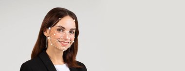 Yüz tanıma teknolojisi özelliklerini incelerken bir insan gülümsüyor. Bu yenilikçi yöntem çeşitli uygulamalarda tanımlama ve doğrulamaya yardımcı olur.