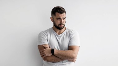 Gücenmiş, üzgün, insanların depresyon duyguları. Suçlu, üzgün, mutsuz, bin yıllık, beyaz duvar arka planında, panoramada, boş alanda sorunları olan çapraz kollu, beyaz, beyaz, beyaz, yakışıklı bir adam.
