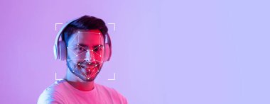 Genç bir adam kulaklık takarken gülümsüyor, yüzünde yüz tanıma teknolojisini gösteriyor. Arka plan canlı bir mor, teknoloji odaklı atmosferi güçlendiriyor..