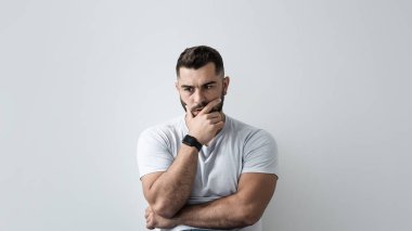 Depresyondaki genç adam evde gri duvara yaslanmış mutsuz, yalnız ve depresyonda, zihinsel sağlıkta üzgün oturuyor. Yoğunlaşmış ciddi şok olmuş çekici, kaslı sakallı adam yerde yatıyor ve düşünüyor.