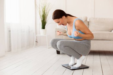 Zayıflama. Evde başarısız bir diyet yaptıktan sonra kiloların üzerinde bağıran kızgın kız. Boş Alan