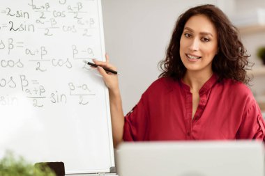 Covid tecrit sırasında e-öğrenme. Üniversite profesörü internet üzerinden matematik öğretiyor, evden online ders veriyor. İnternette bilgisayar kullanarak matematik problemlerini açıklayan bin yıllık öğretmenin portresi